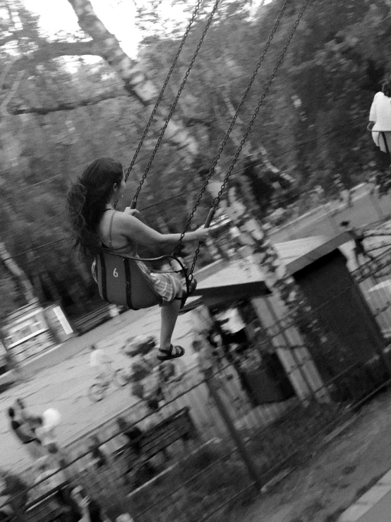 girl on swings in the park swinging her leg