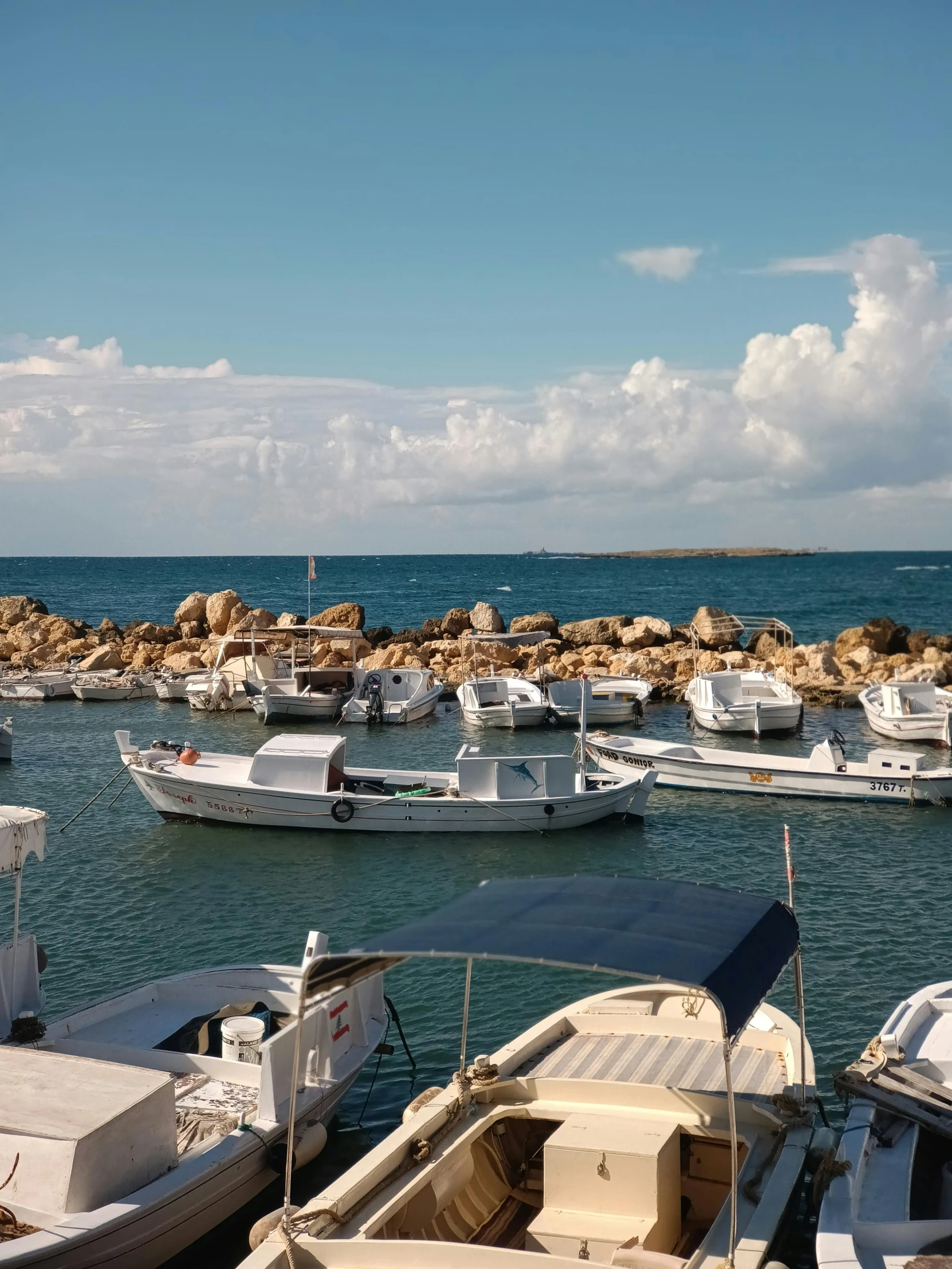 several boats are sitting on the water next to each other