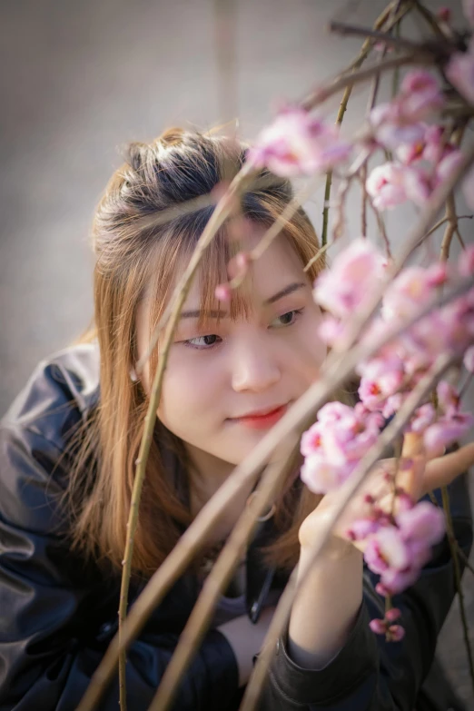 woman standing near pink flowers looking up