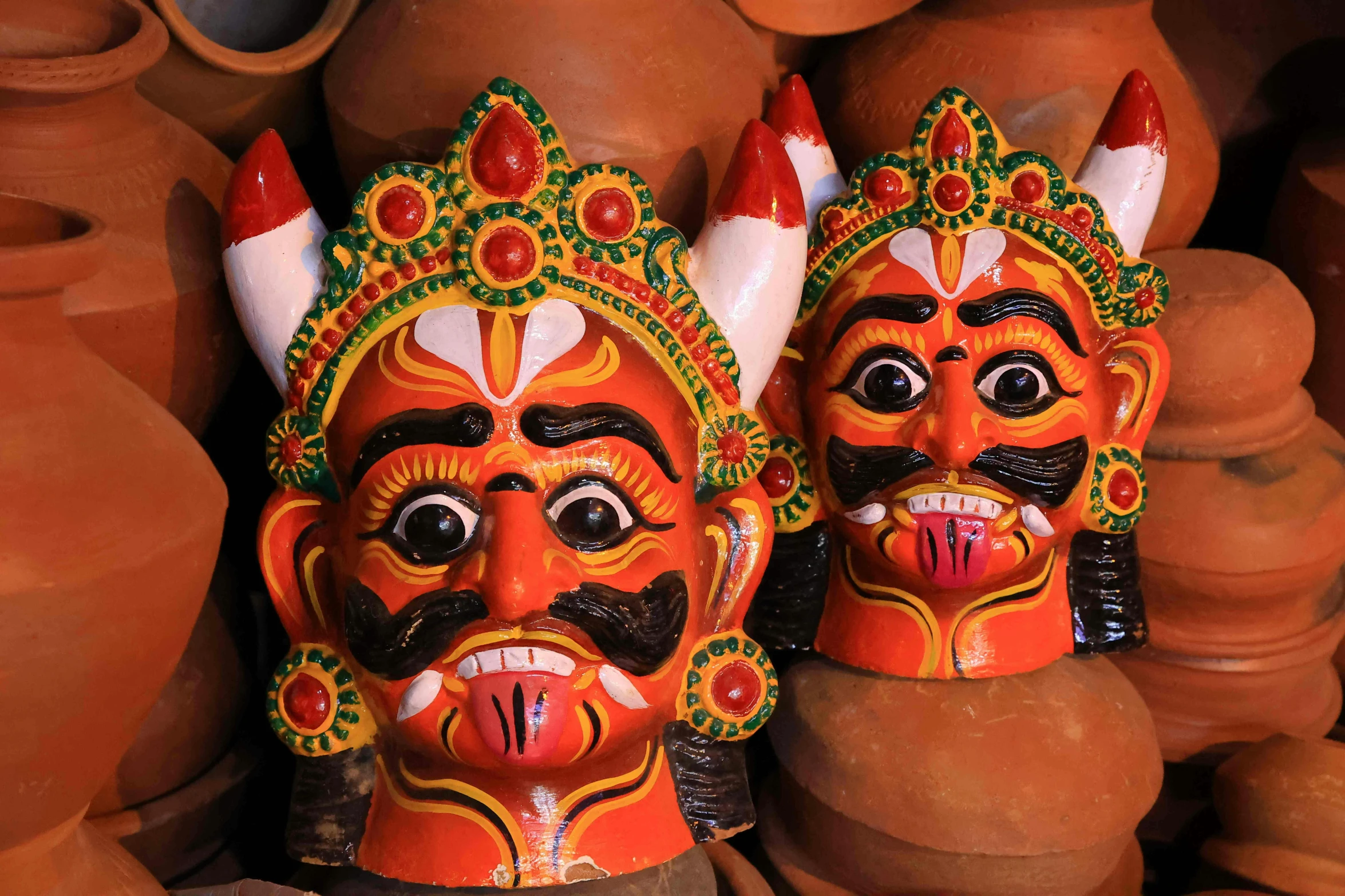 two small statues in orange and black sit next to each other