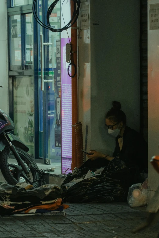 person on street looking at broken bike near shop