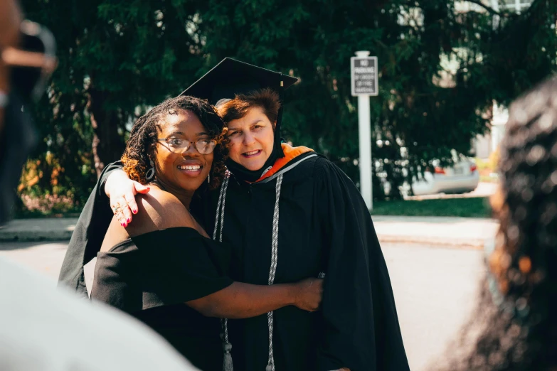 two women hugging each other after graduation