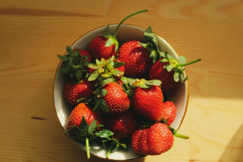 fresh strawberries are sitting in the bowl on the table