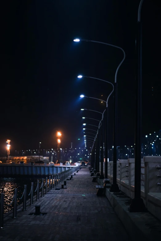 some lamps on poles and buildings in the dark