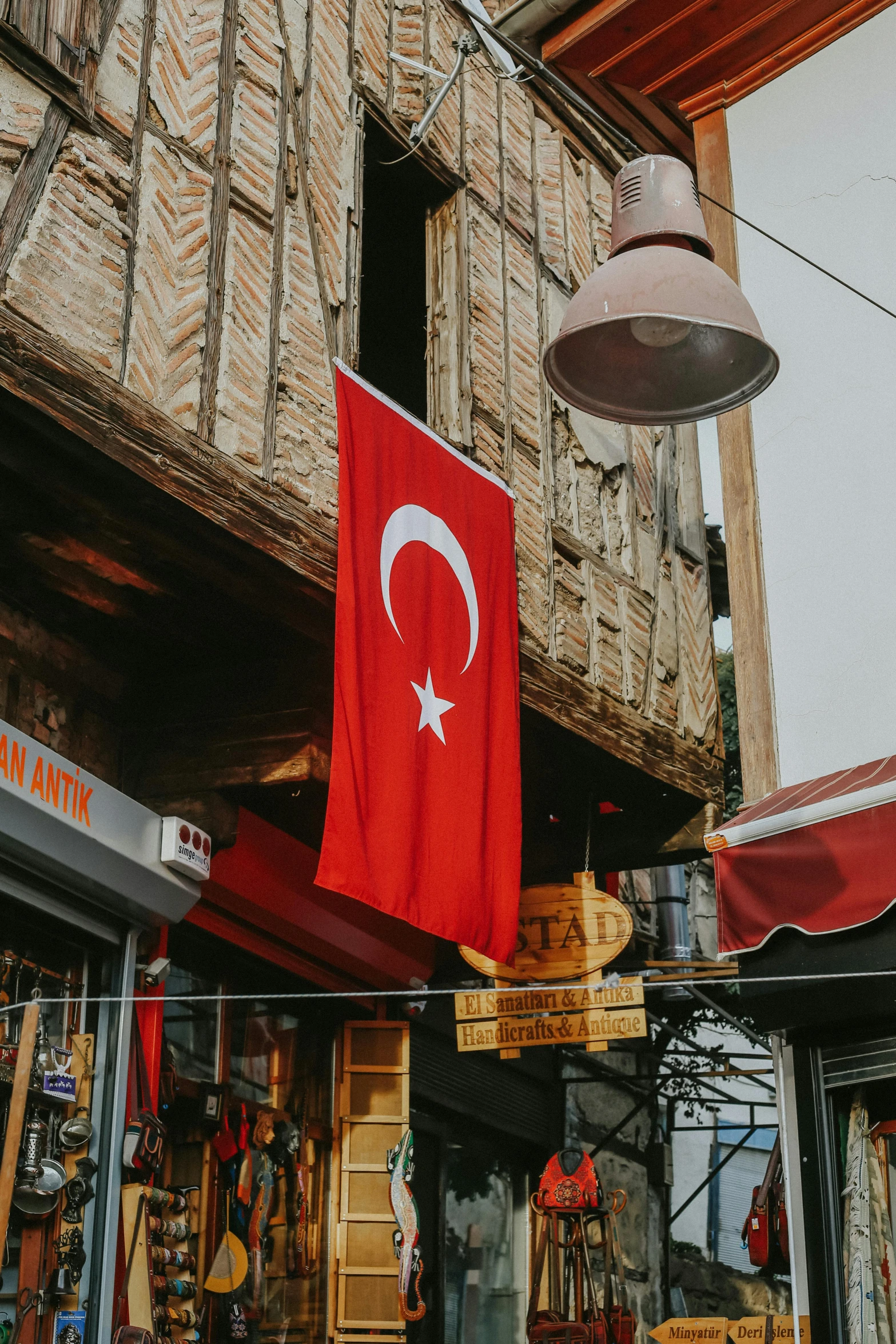 the turkey flag hangs on a street outside a shop