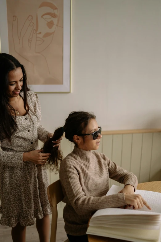 the woman is using her hair while her hair is being straightened