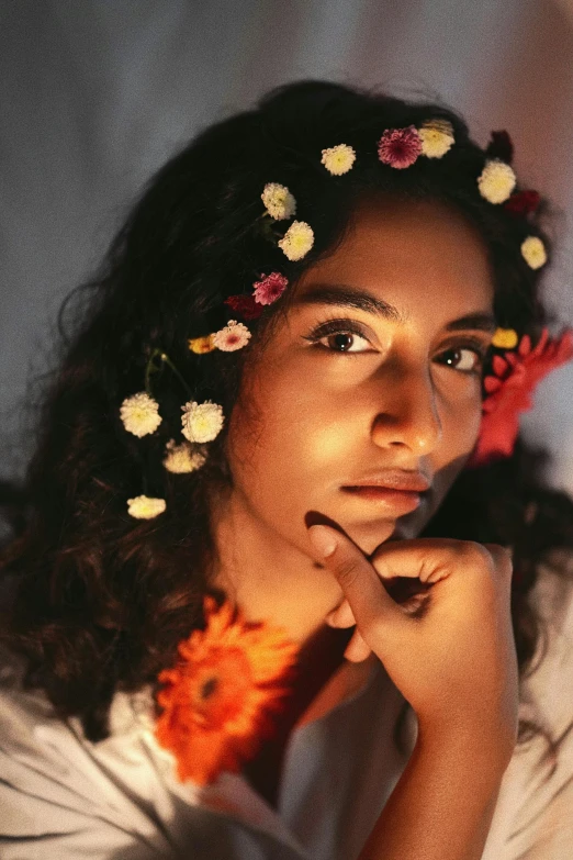 a woman with flowers in her hair looking at soing