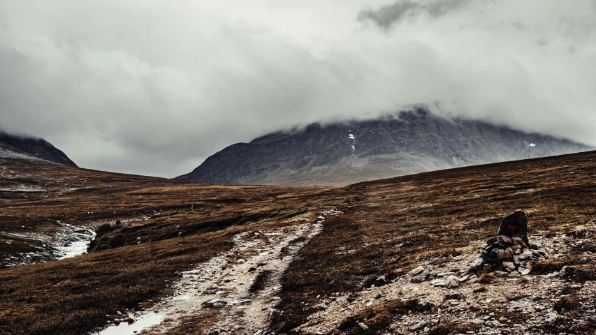 a man hiking up a mountain with a mountain background