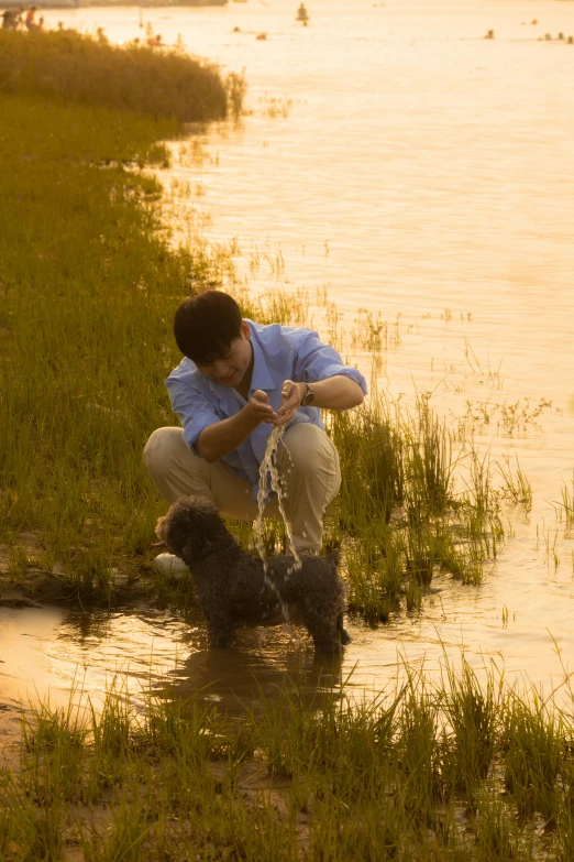 a man who is pouring water over a dog