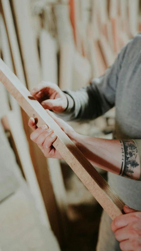 the two hands are working with a piece of wood