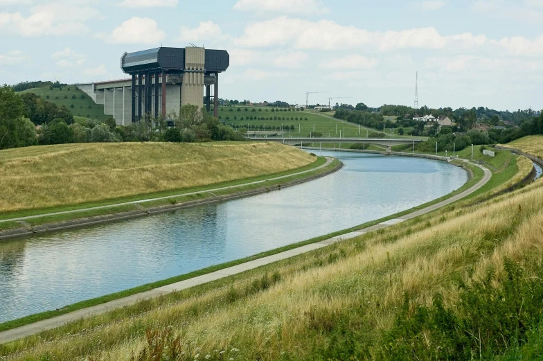 a water tower over a wide river in a field