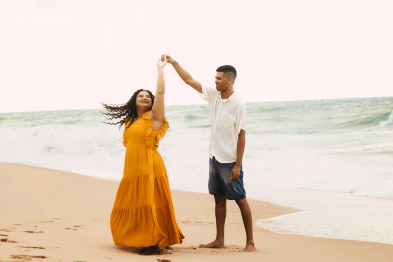 a man and woman dancing at the beach