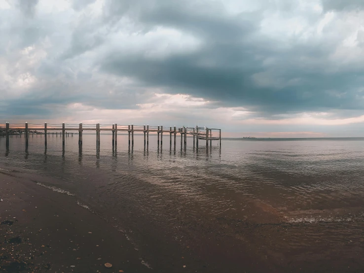 a pier with a couple of birds sitting on it's posts