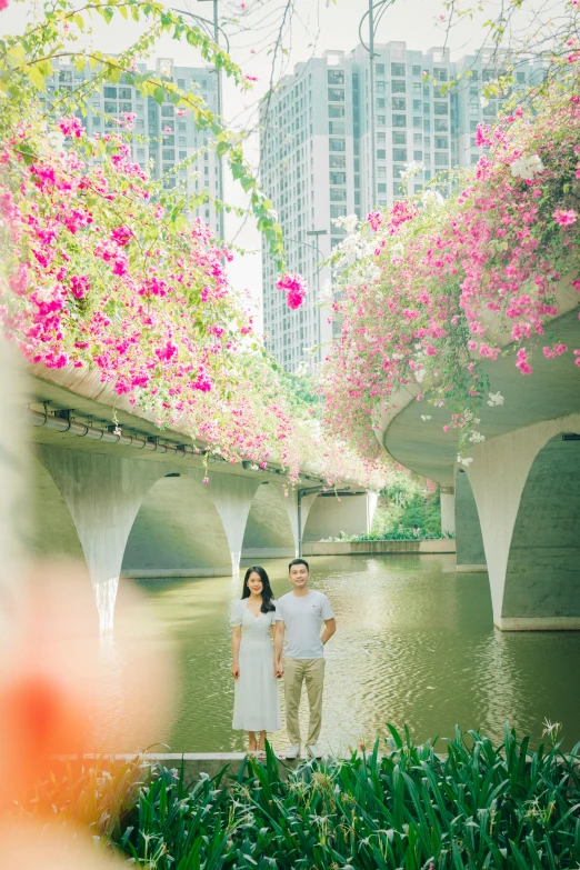 a man and woman are standing on a bench in front of the water