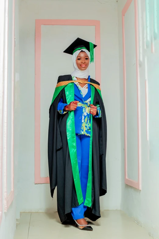 a woman with a graduation cap and gown stands in a narrow passageway