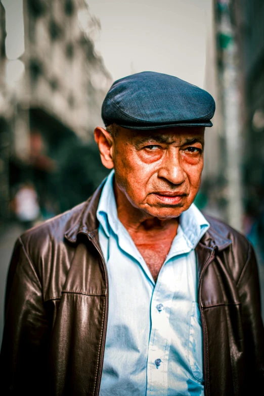 an elderly man in a brown jacket wearing a hat