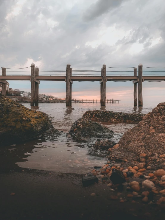 this is a bridge in the ocean with many poles over it