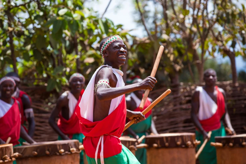 an african woman playing drums at the end of a festival