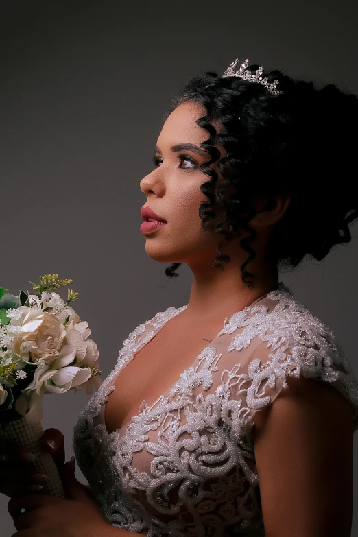 a beautiful black woman in a white wedding gown holding a bouquet of flowers