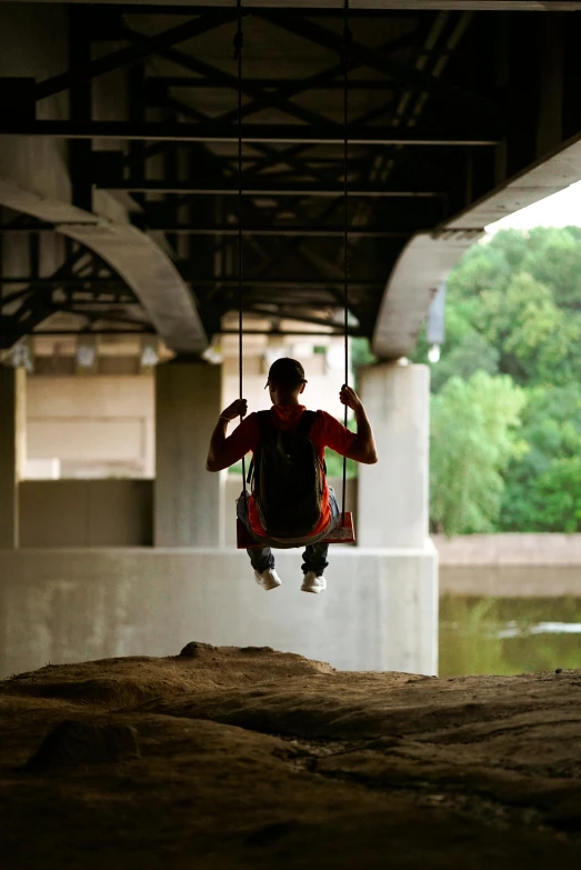 a man swinging from a swing above a body of water