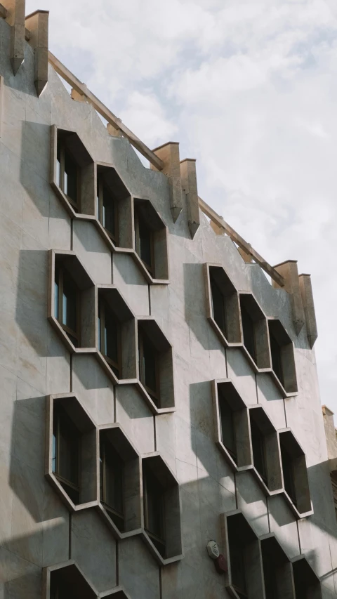 the building is made of concrete and has geometricly spaced windows