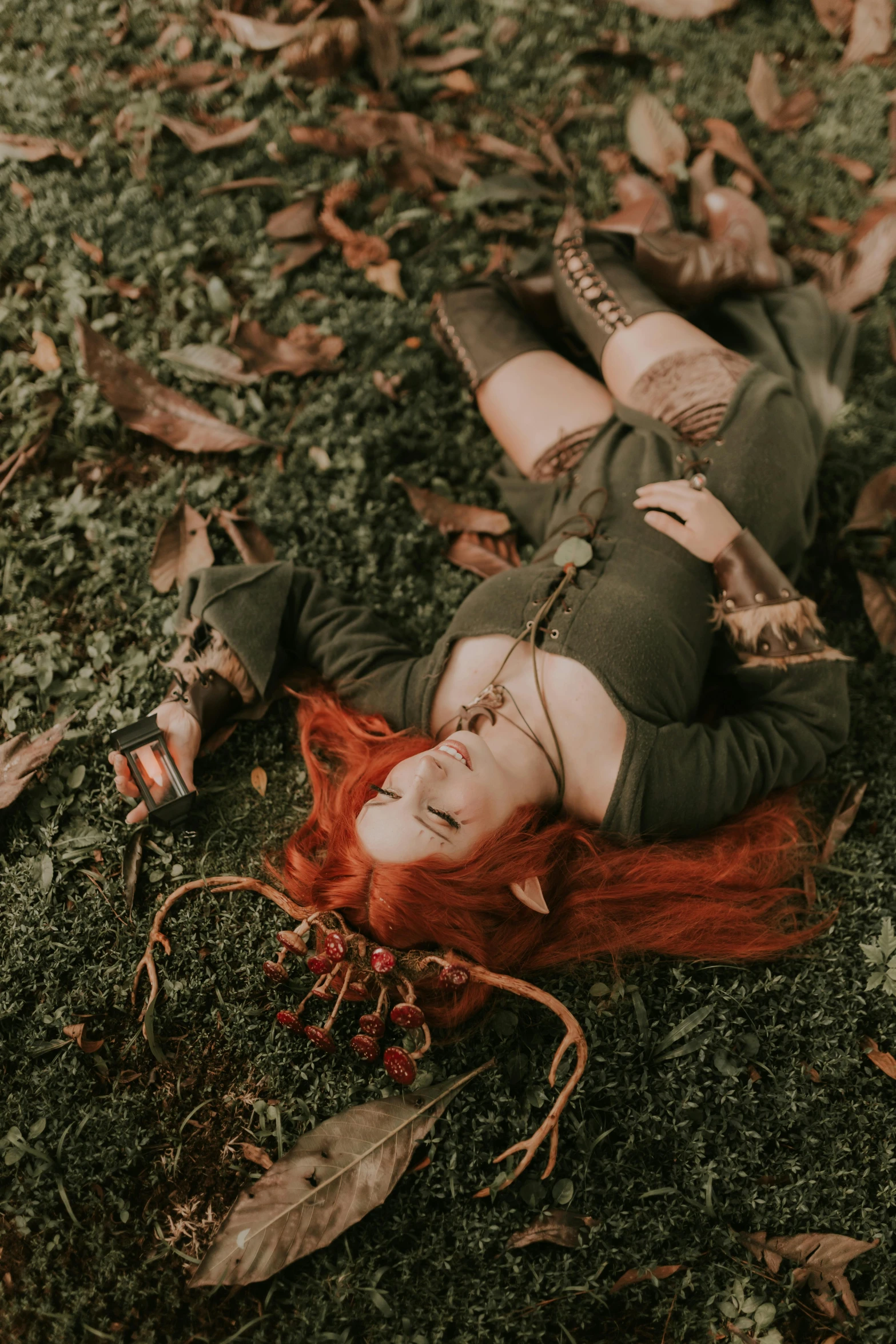 a girl in a green dress lies on a grass area