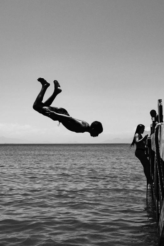 two people doing tricks off of a boat