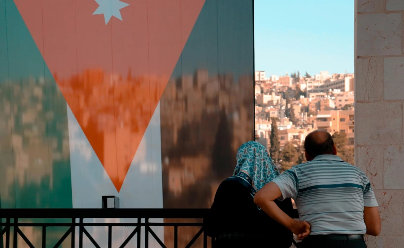 a couple of people that are standing near a fence