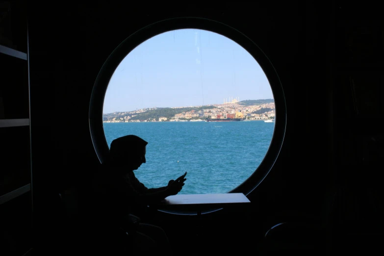 a person looks out from under a round window