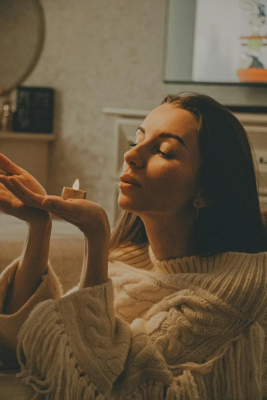 a woman is sitting in the living room and smoking a cigarette