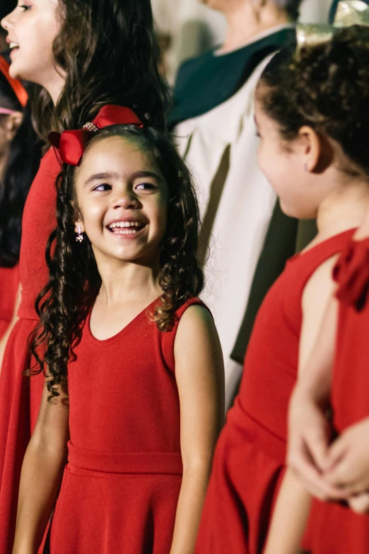 a  in a red dress smiles at a band