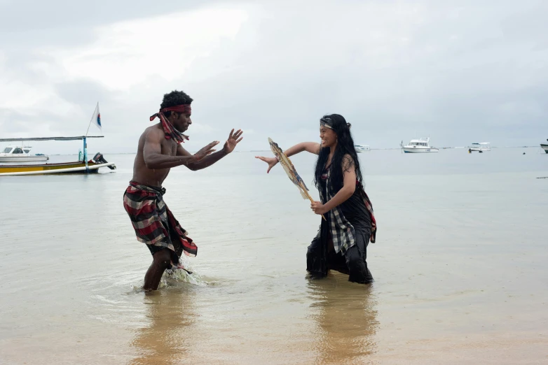 a man and woman standing in the water at the beach