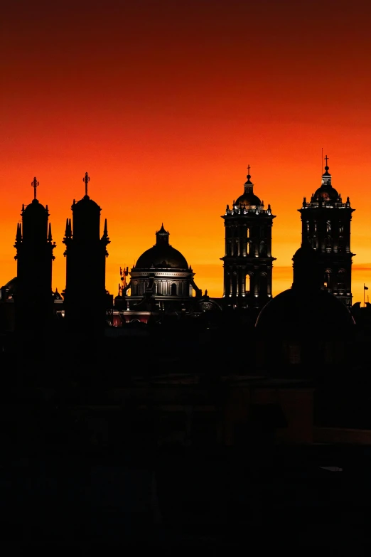 two large buildings in the distance near some sunset