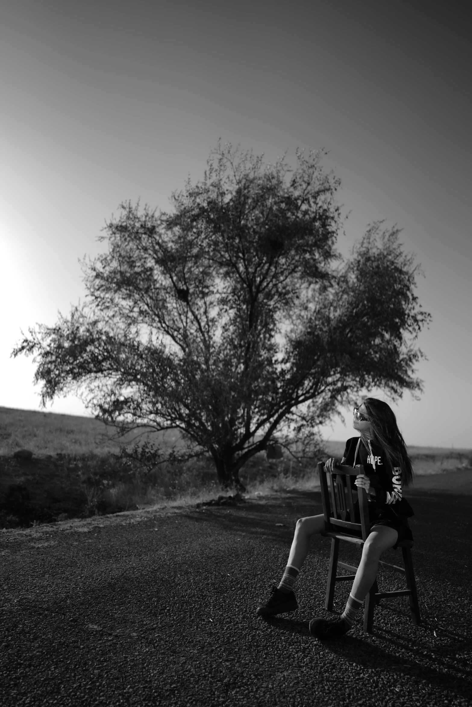 there is a young woman sitting on the bench and reading a book