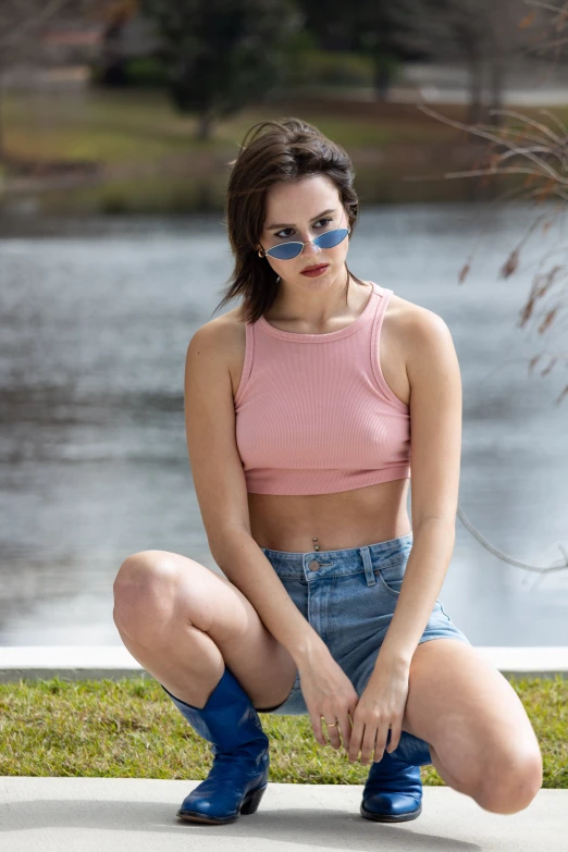 woman in pink crop top sitting next to the water
