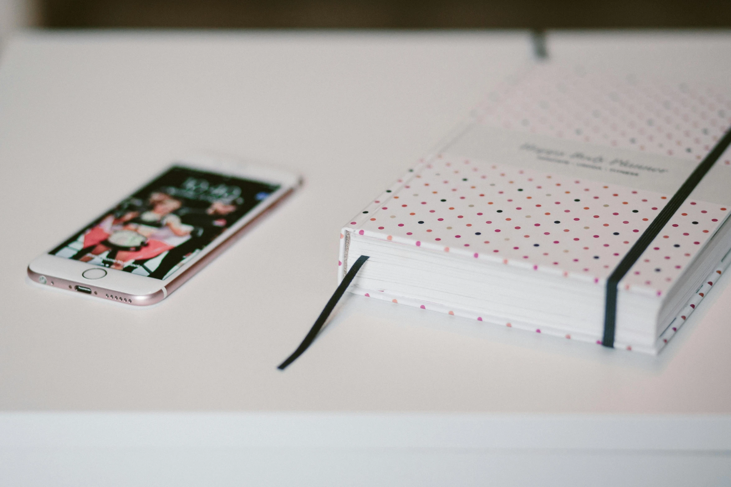 a cellphone and a small notebook sitting on top of a table