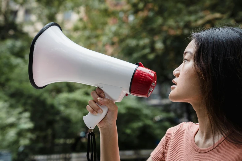 a woman blowing the horn on top of a small toy bullhorn