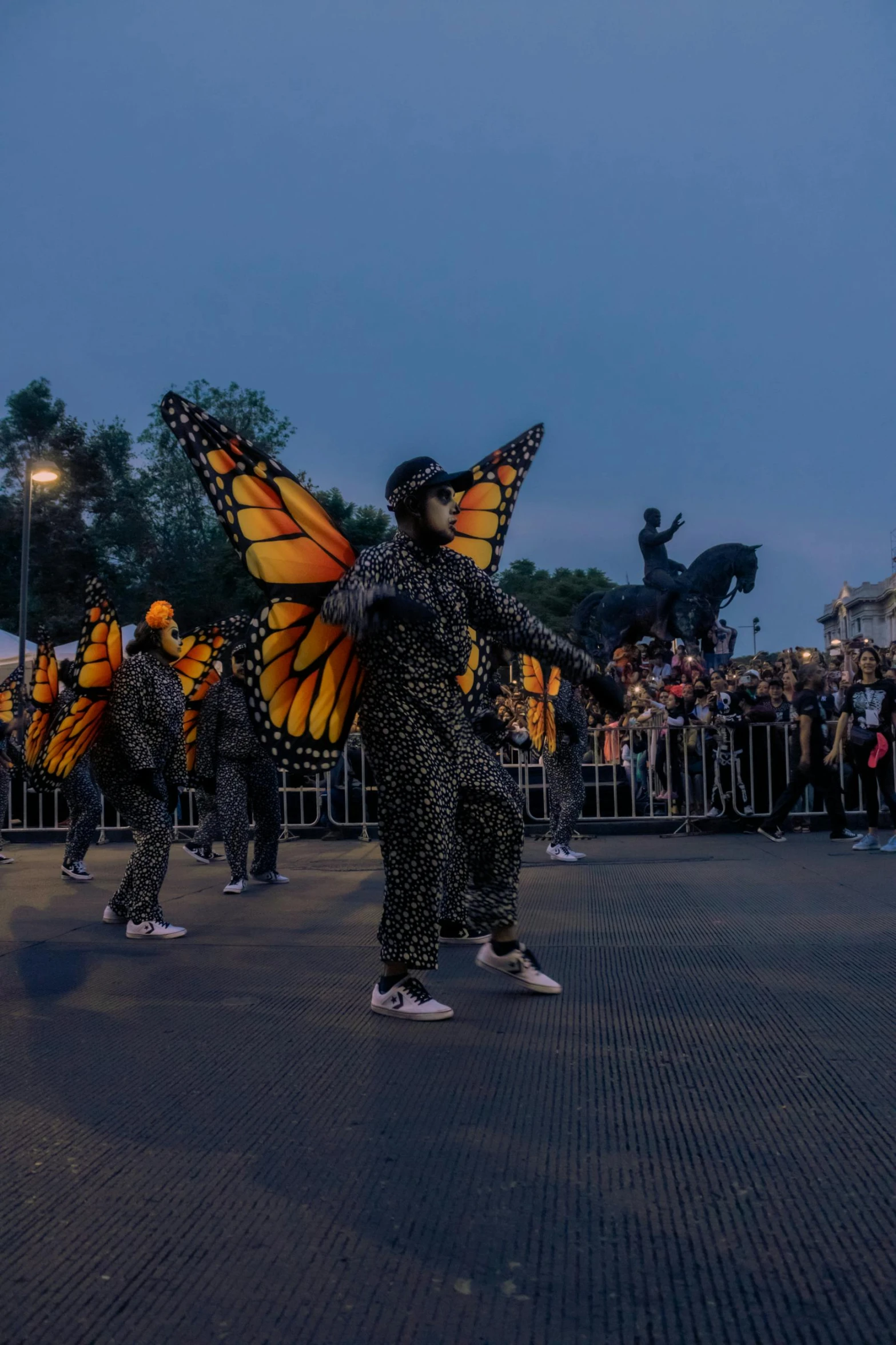 people walking on a city street with costumes in the shape of a erfly