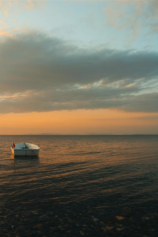 a white boat sitting in the middle of the ocean