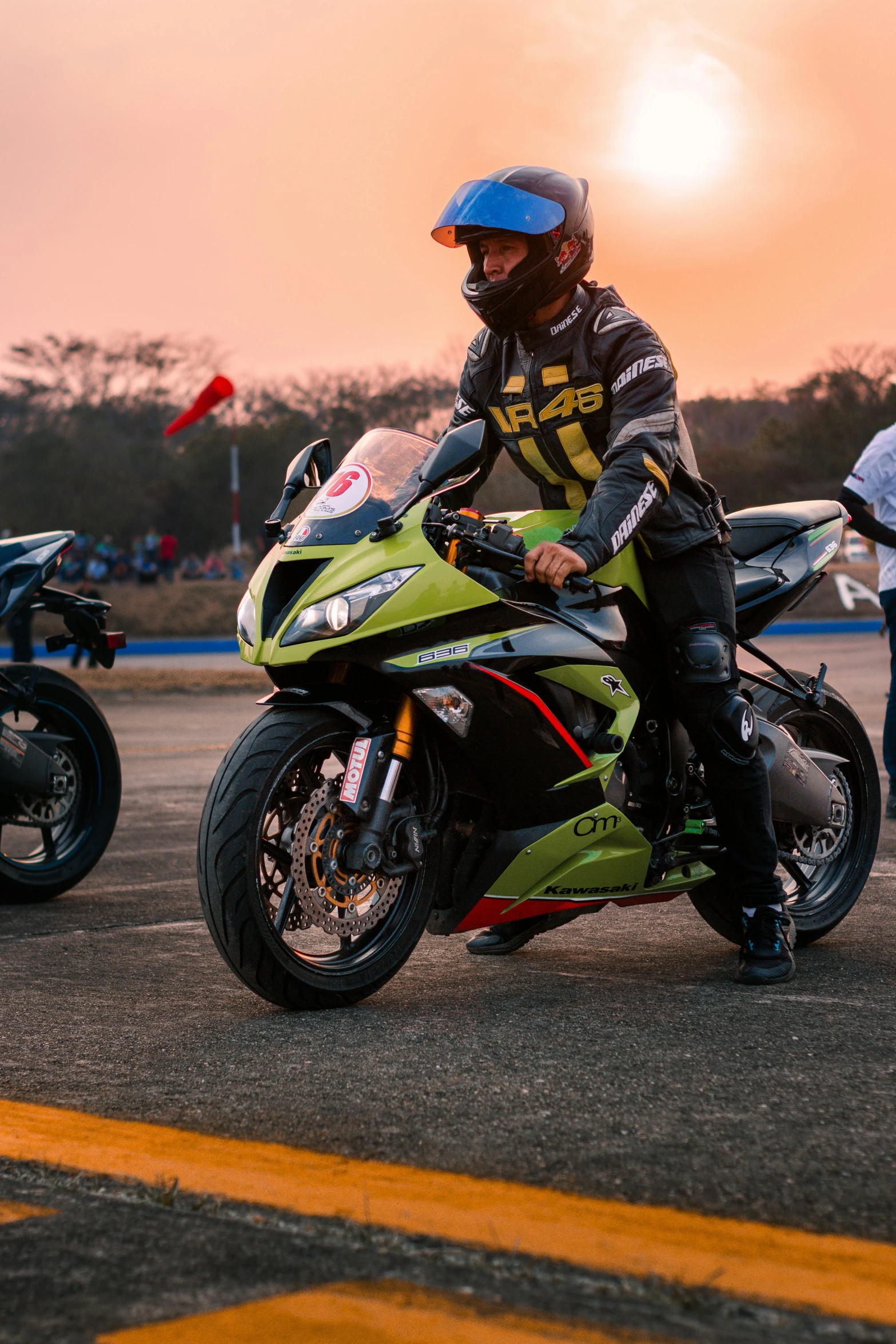 a person riding on a green and black motorcycle