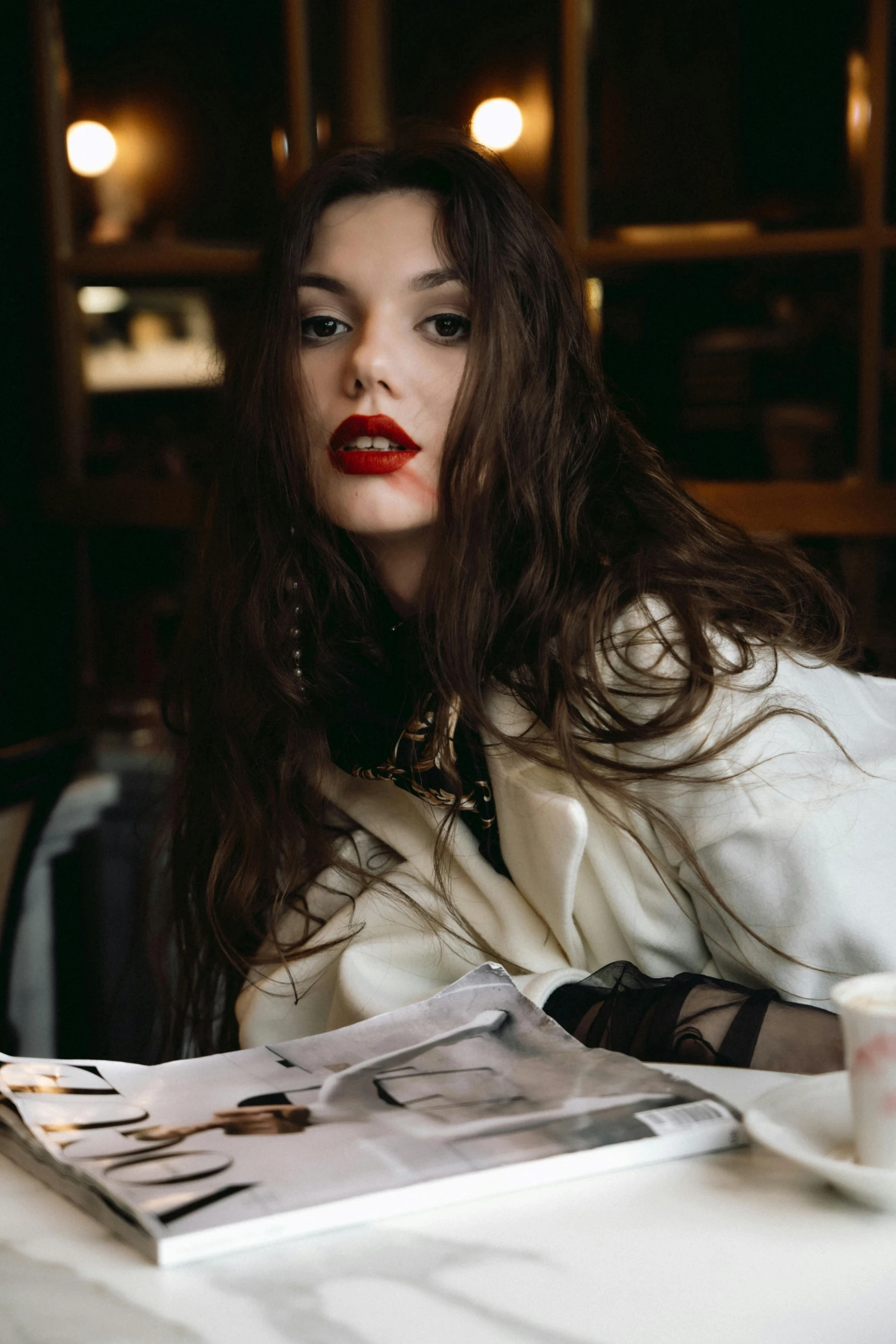 a woman is sitting at a table looking at the camera