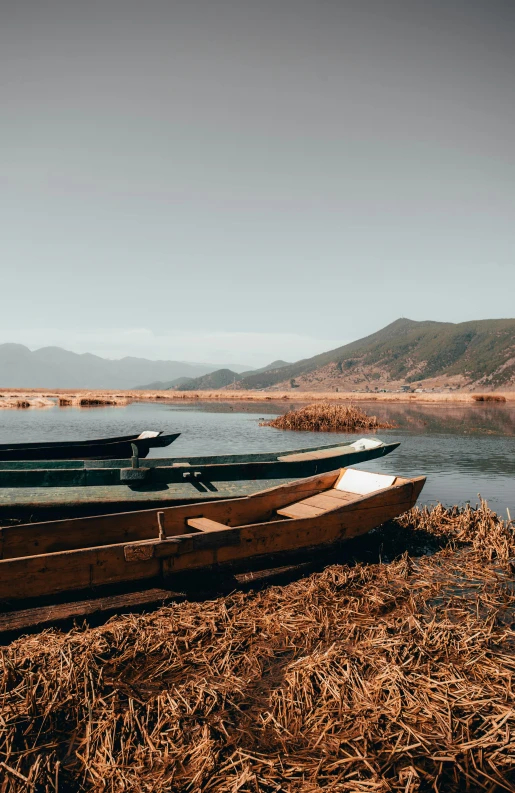 two boats on the ground in front of the water