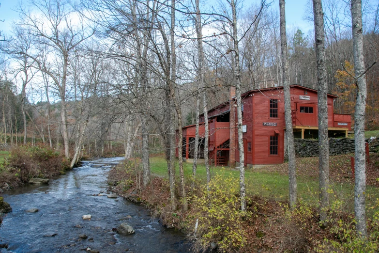 a long brick building stands in a wooded area
