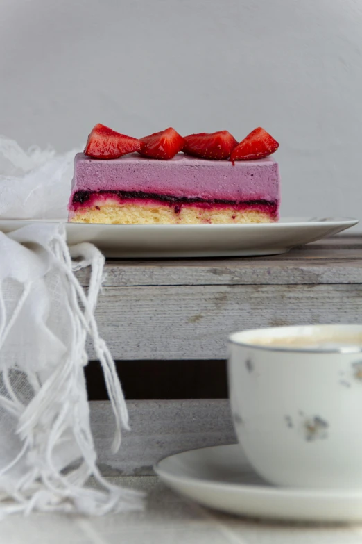 strawberry mousse cake sitting on top of a plate