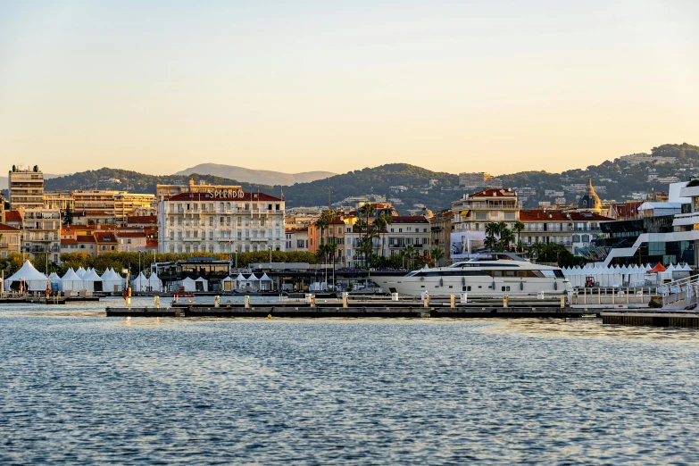 some white buildings on some water with mountains in the background