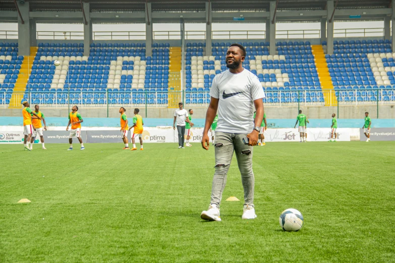 a man is practicing soccer in an empty stadium