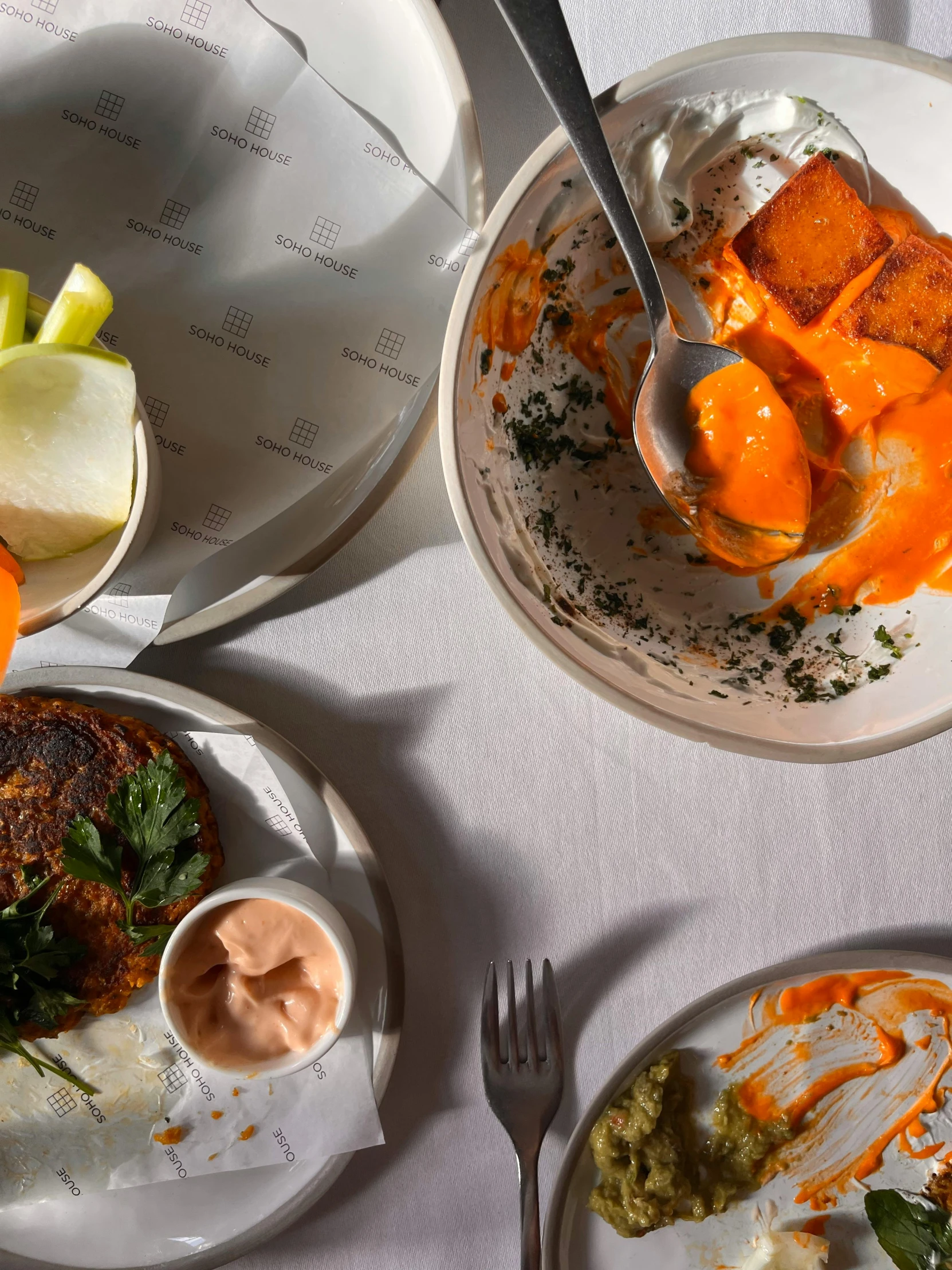 three plates of food with forks on a table