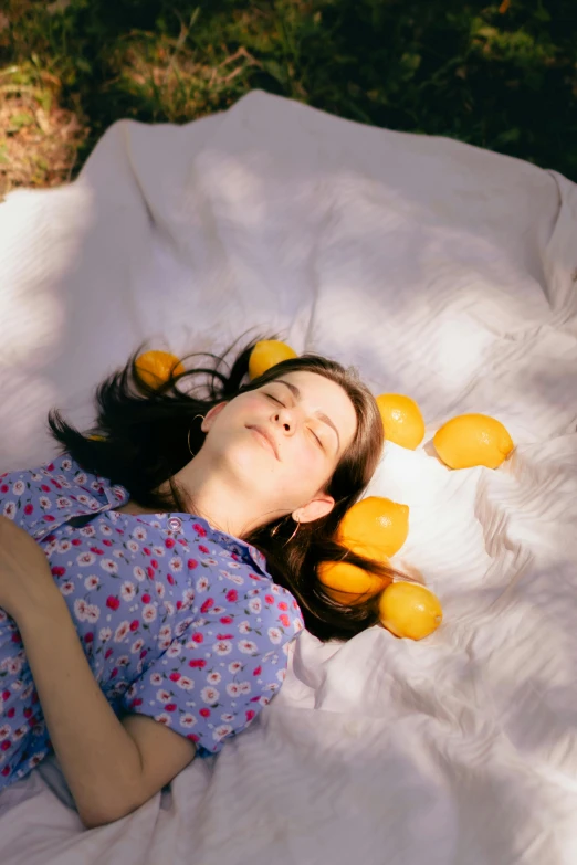 a young woman laying on her stomach on top of white blanket