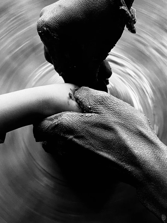 black and white image of a person's hand above water