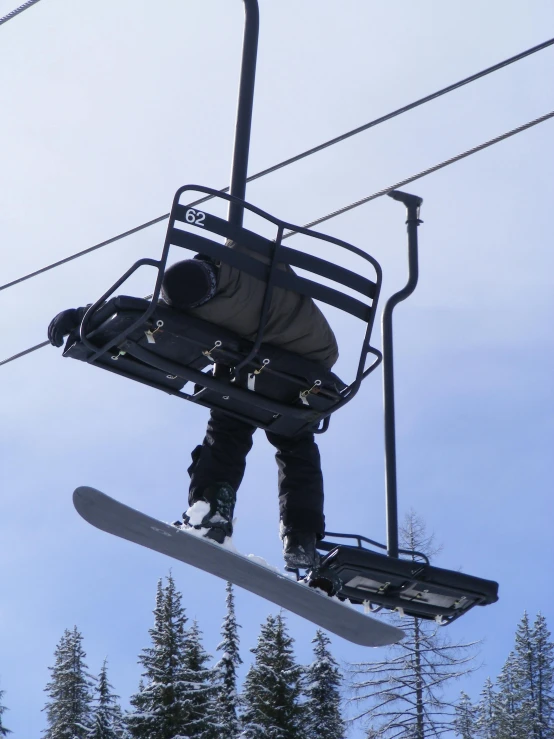 snowboarder jumping in mid air after coming off the lift